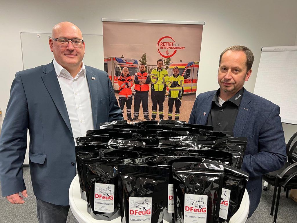 Exemplarische Kaffeepäckchen. Lars Wieg (stv. Bundesvorsitzender DFeuG), Siegfried Maier (Vorsitzender DFeuG)